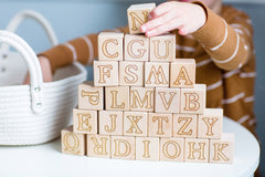 Child stacking wooden abc blocks